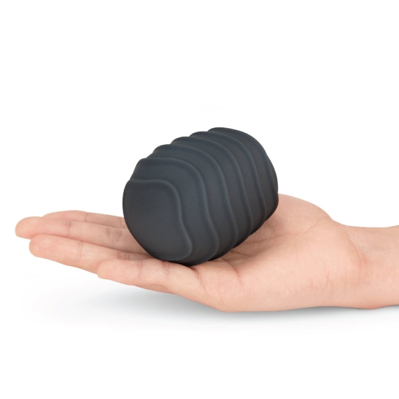 A dark gray textured silicone massager cover rests on an open palm.