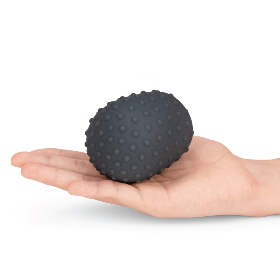 Dark gray textured silicone massager cover on a hand.