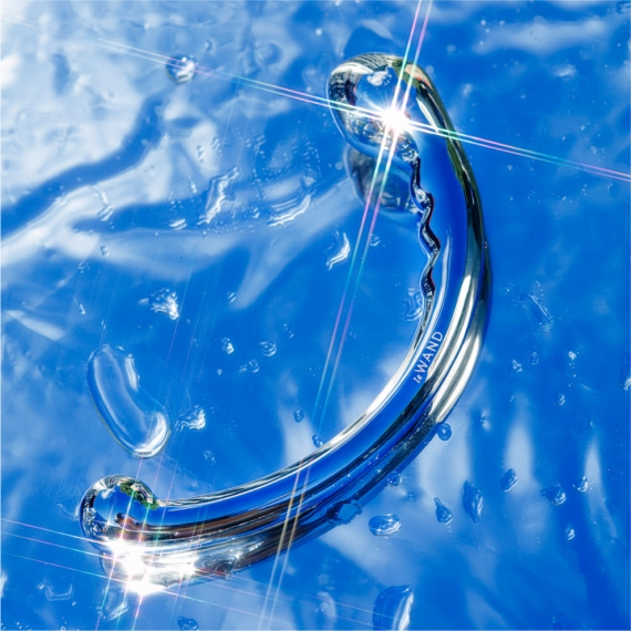 Curved stainless steel wand with a bulbous end on a blue, wet surface.