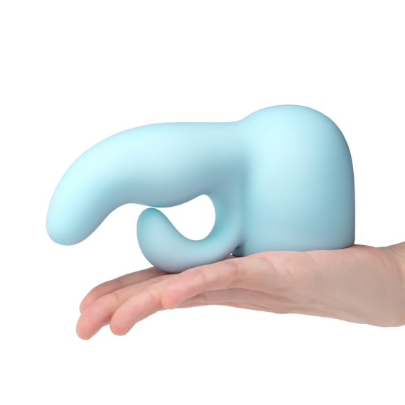 A light blue silicone wand attachment with a curved shape rests on a hand.