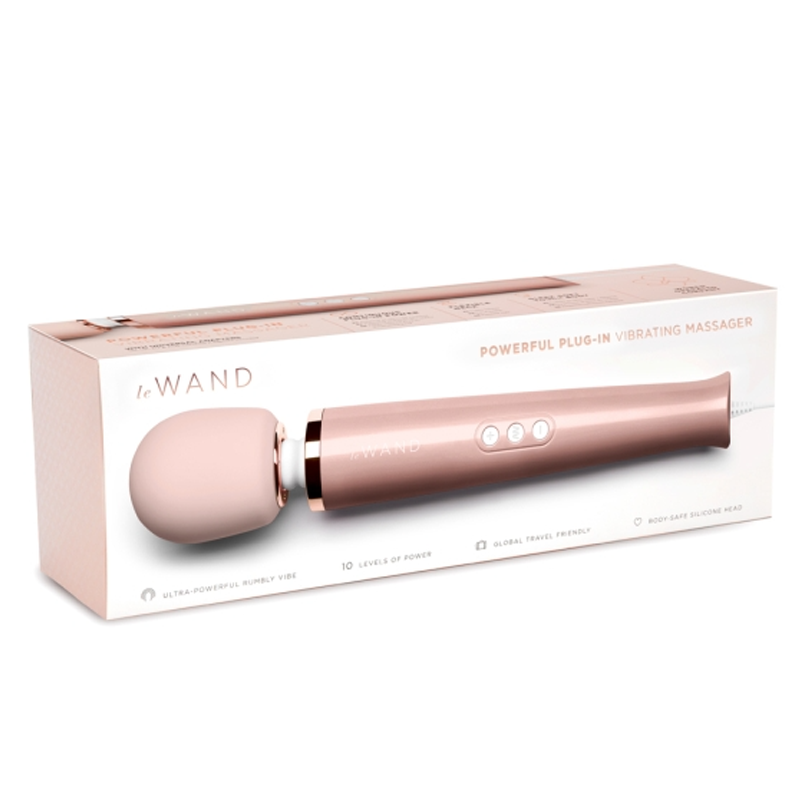 A rose gold Le Wand plug-in vibrating massager with a pink silicone head.