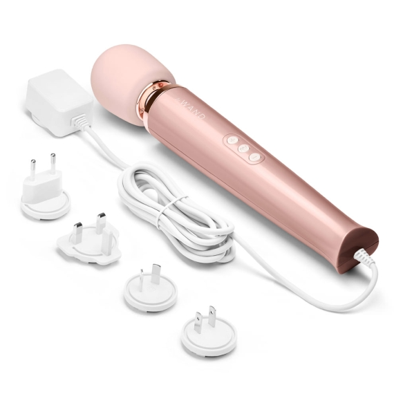 Rose gold plug-in wand massager with white cord and multiple plug adapters.