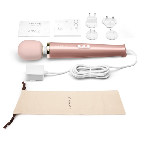 A rose gold Le Wand plug-in massager with accessories and a storage bag.