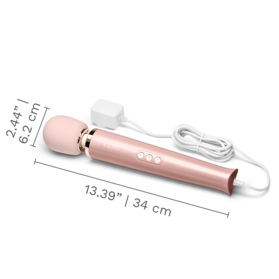 A rose gold plug-in wand massager with a white cord and charger.
