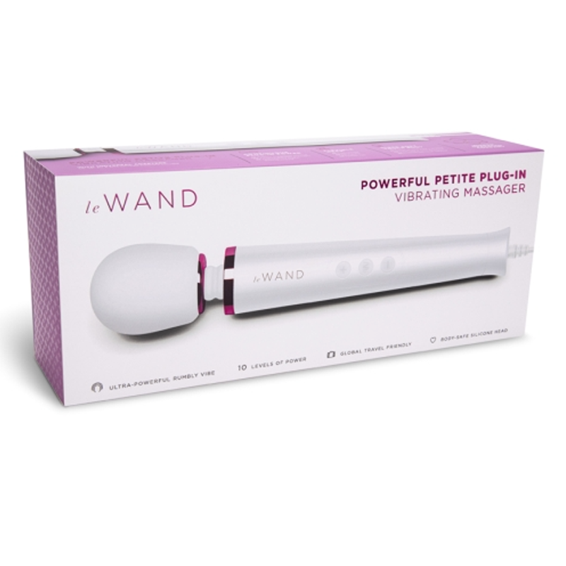 A white Le Wand petite plug-in vibrating massager with a pink accent on a box.