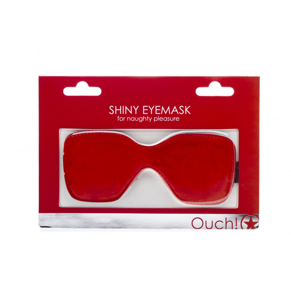 Shiny red satin eye mask with elastic strap on packaging.