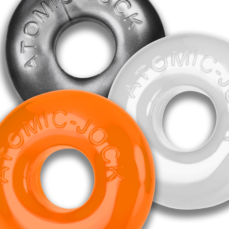 Three stretchy cock rings in orange, gray, and white, each with "ATOMIC-JOCK" embossed.