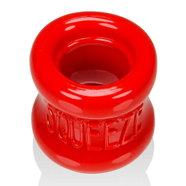 A red, flexible ball stretcher with the word "Squeeze" embossed on it.