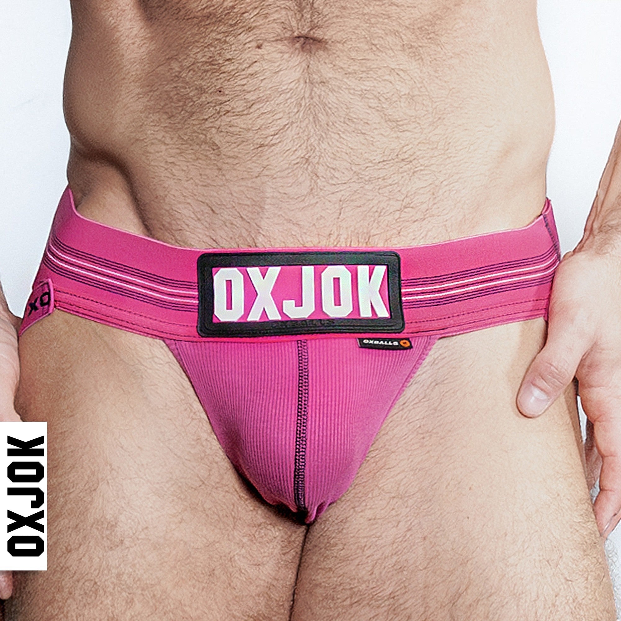 Pink ribbed jockstrap with black and white striped waistband and "OXJOK" logo.