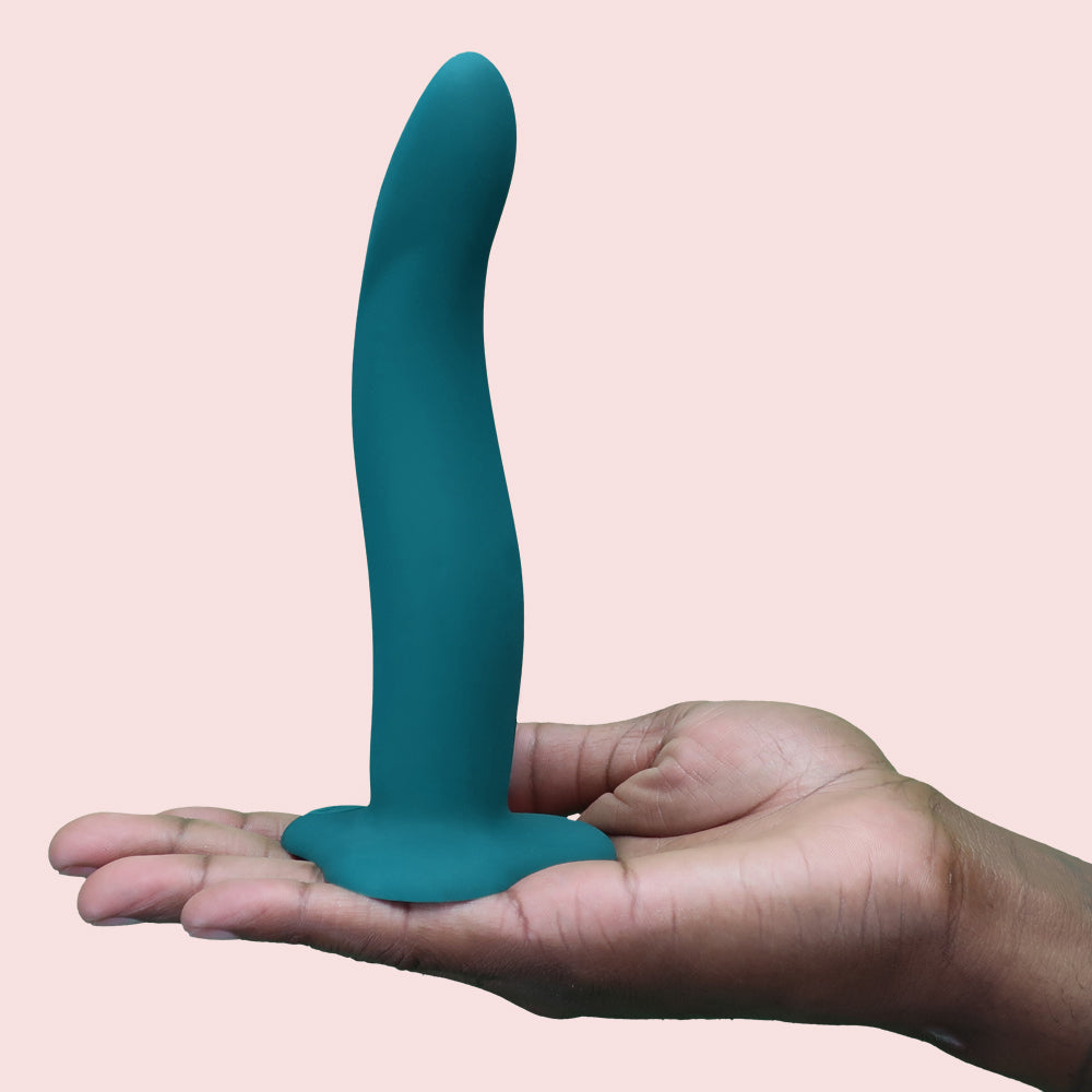 Teal flexible G-spot toy held in a hand.
