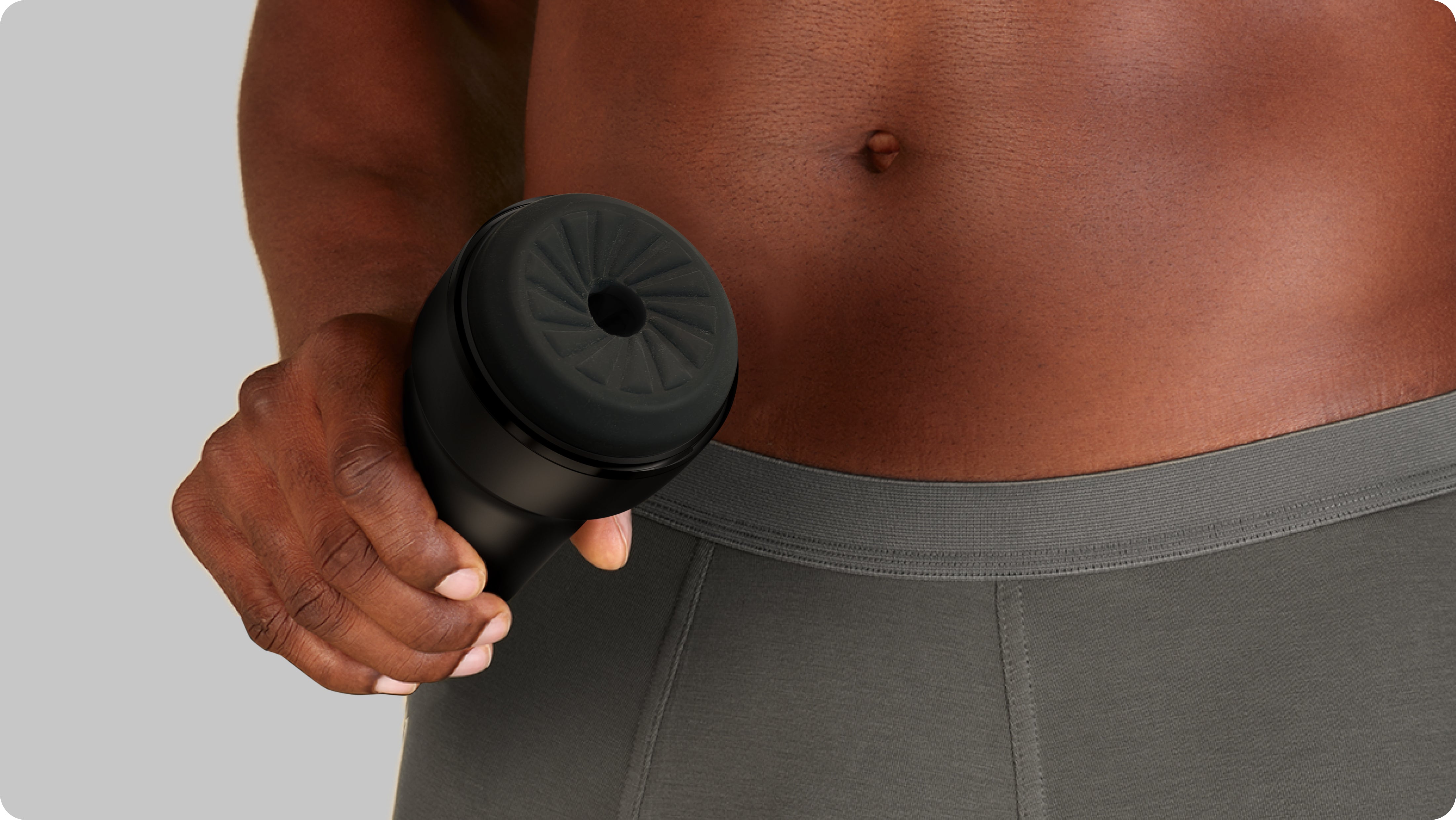 Black Feel Pocket Stroker male masturbator held by a hand.