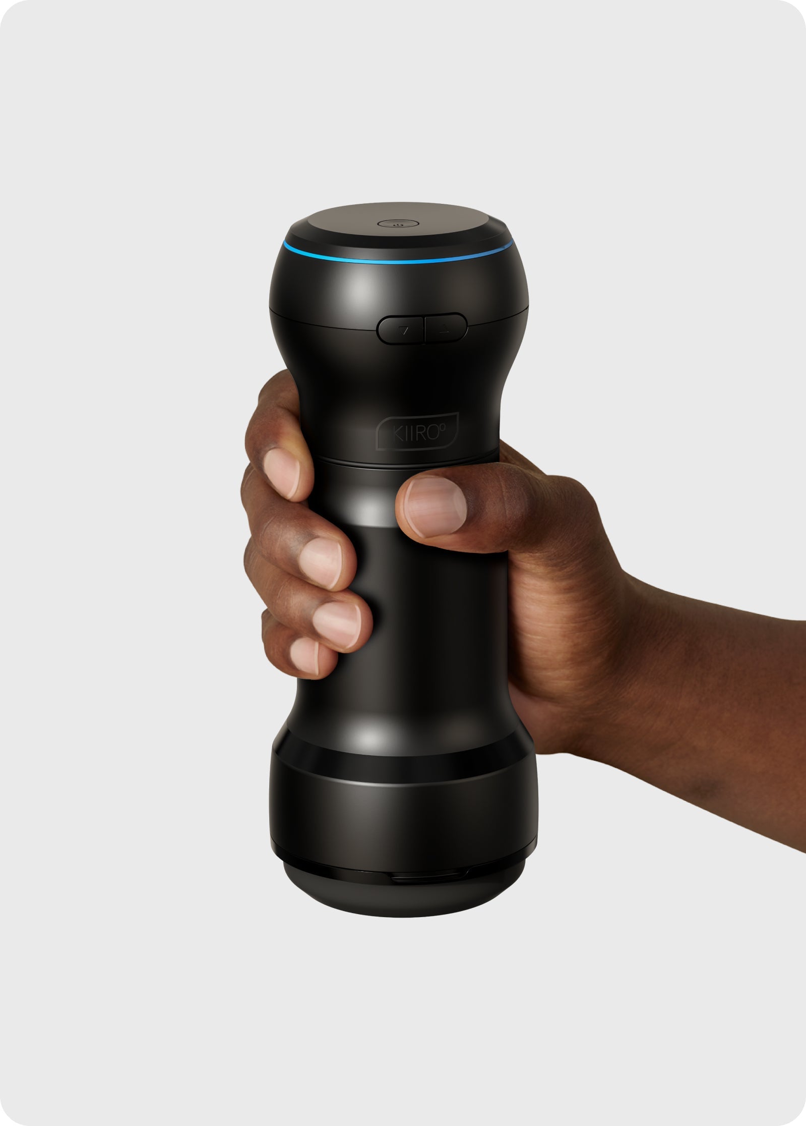 Black Kiiroo app-controlled stroker and suction device held in a hand.
