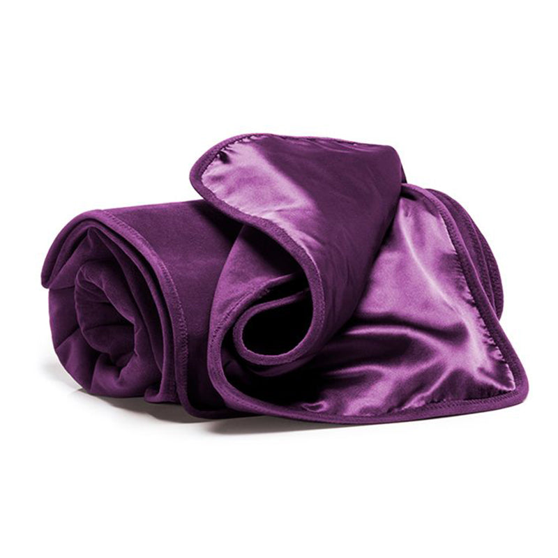 A rolled aubergine waterproof microvelvet throw blanket with a satin trim.