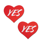 Two red heart-shaped nipple pasties with the word "YES" in white.