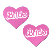 Two pink heart-shaped nipple pasties with "Bride" written in white.