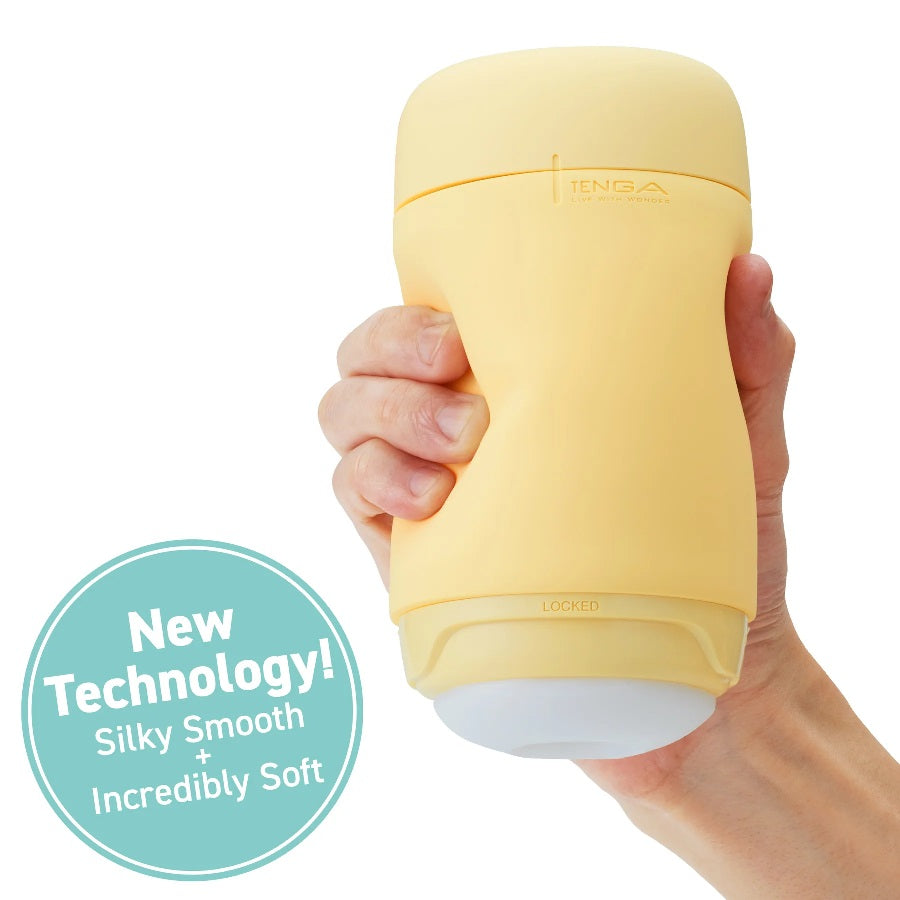 A yellow Tenga Puffy stroker with soft spiral ribs held in a hand.