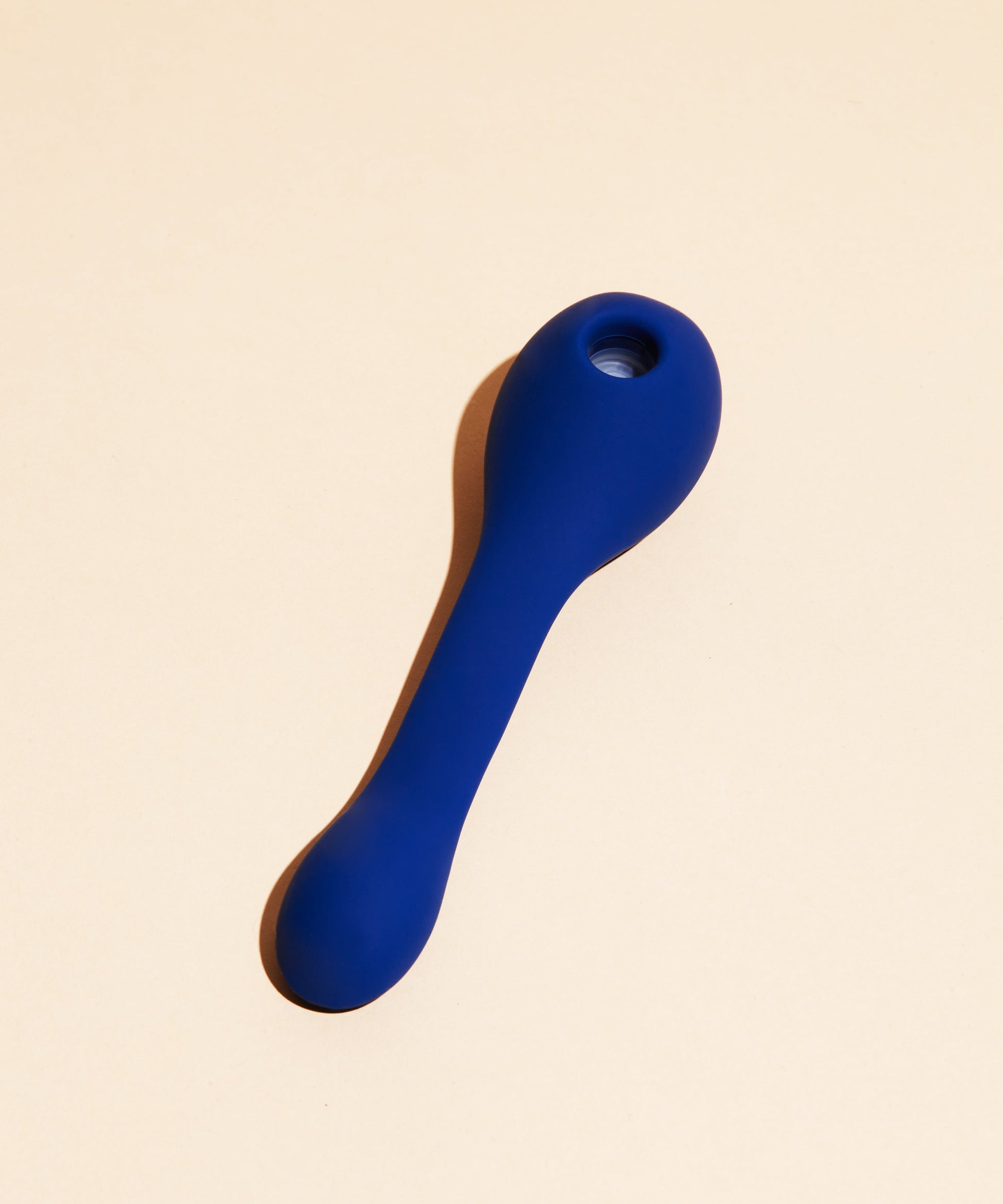 A blue silicone vibrator with a rounded head and a long, curved handle.