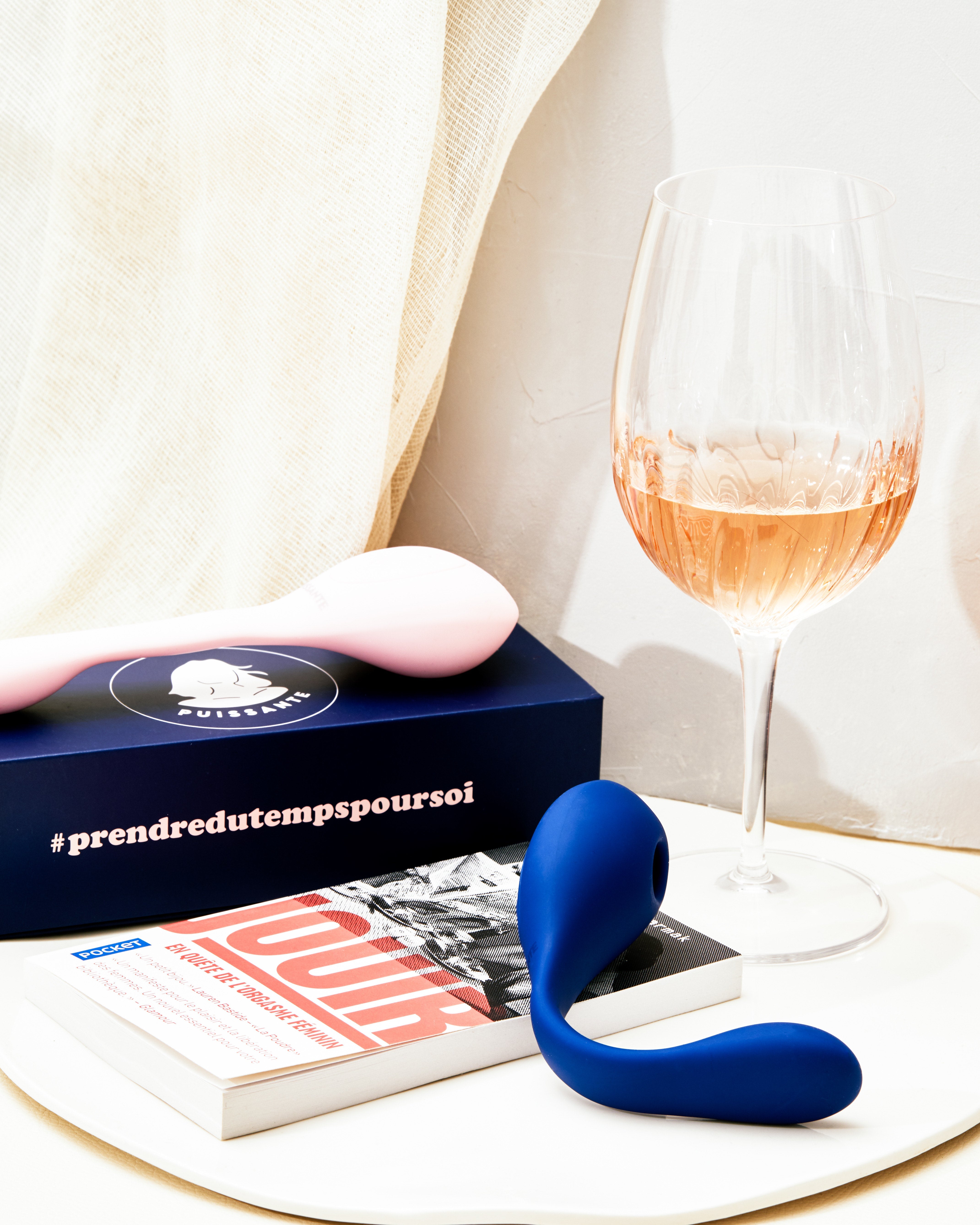 Coco Dual Stimulation Waterproof Silicone Vibrator in blue with a book and wine glass.
