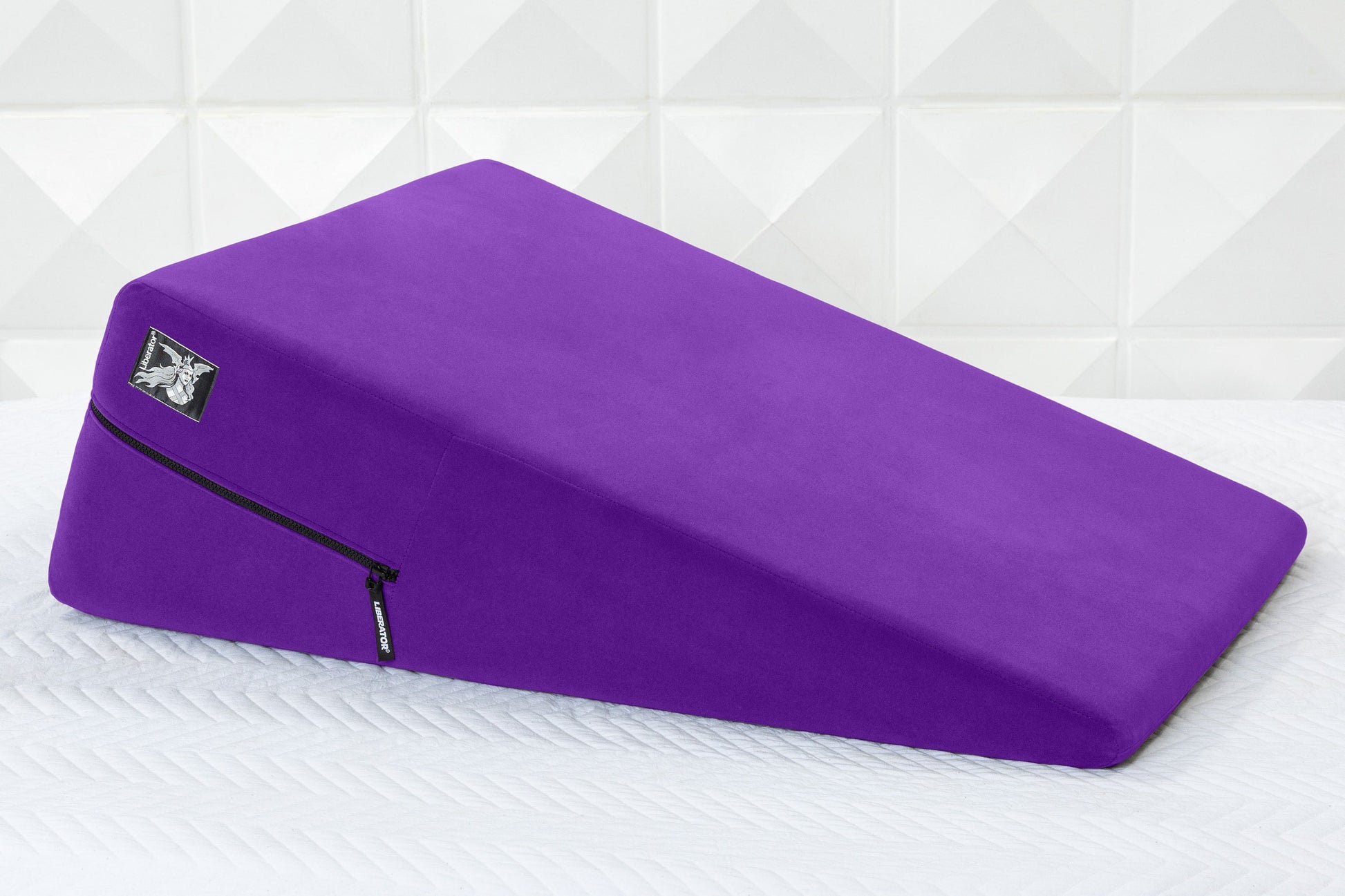 Purple wedge-shaped positioning pillow with a microfiber cover and a zipper.