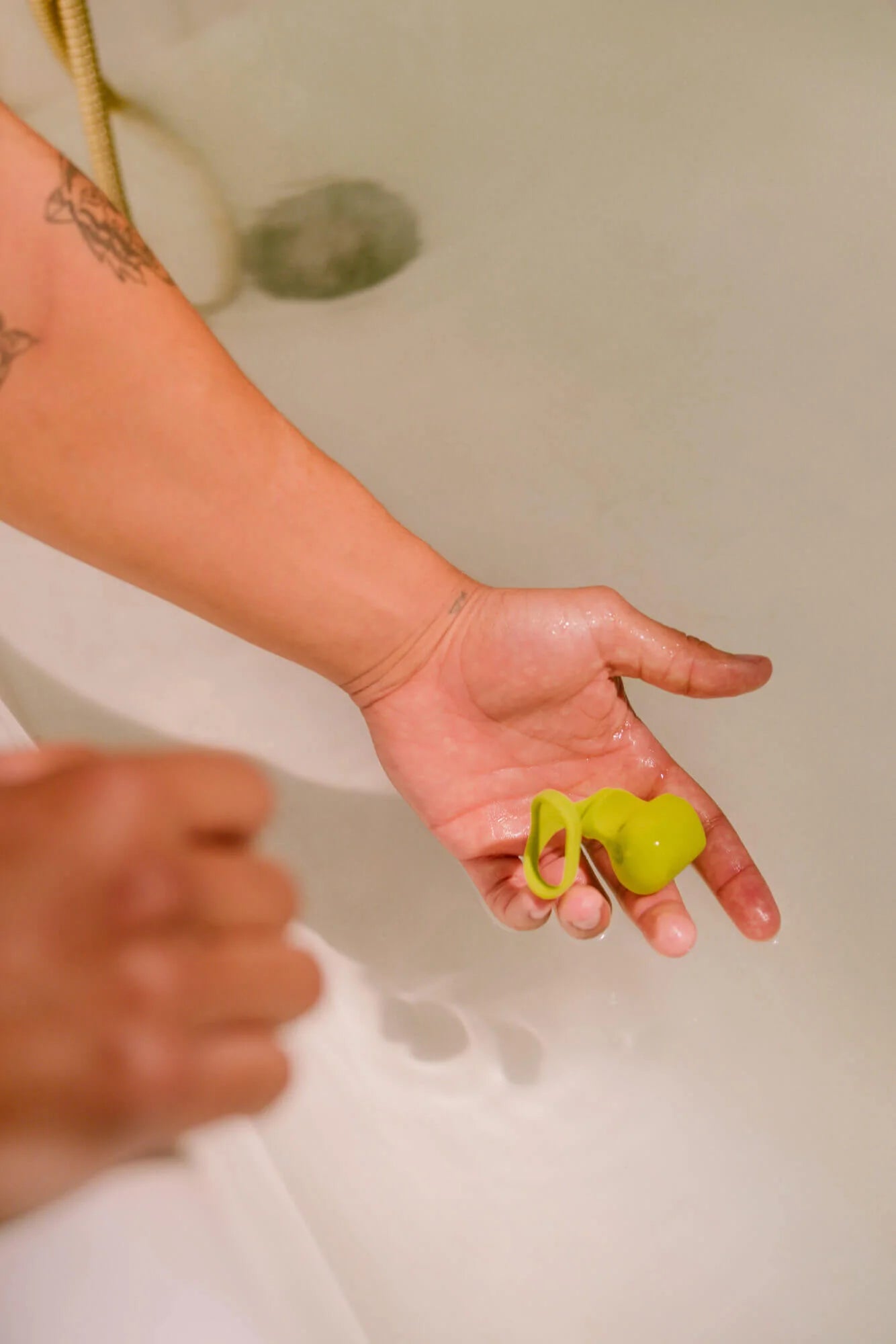 A lime green silicone finger vibrator with a loop.