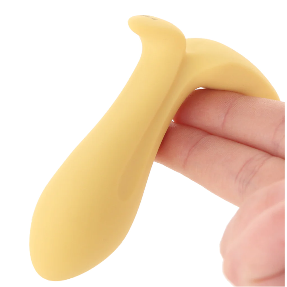 A gold vibrating anal plug with an ergonomic design is held by a finger.
