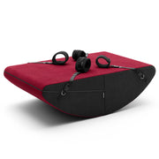 A red and black rocker positioning cushion with restraints.