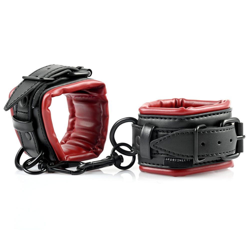 Black and red faux leather cuffs with metal chain and rings.