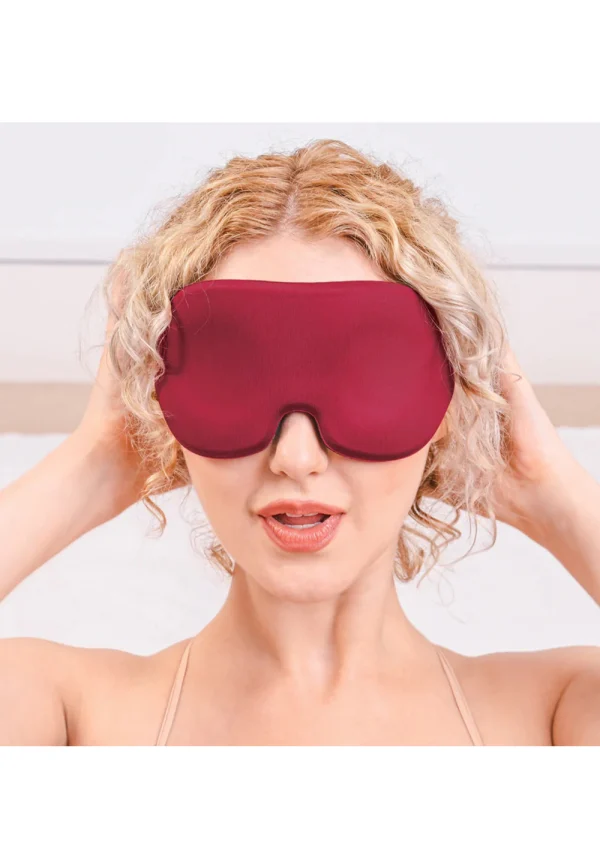 A burgundy memory foam blindfold with contoured eye and nose divots.