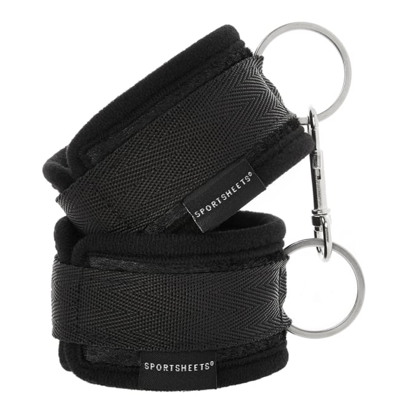 Black soft-lined wrist cuffs with hook and loop closure and metal rings.