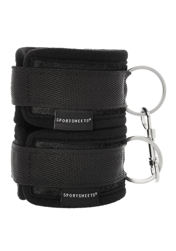 Black soft-lined wrist cuffs with hook and loop closure and metal rings.