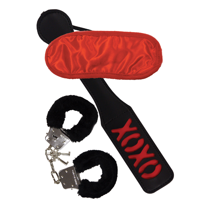 A BDSM kit with a red blindfold, black fuzzy handcuffs, and an XOXO paddle.