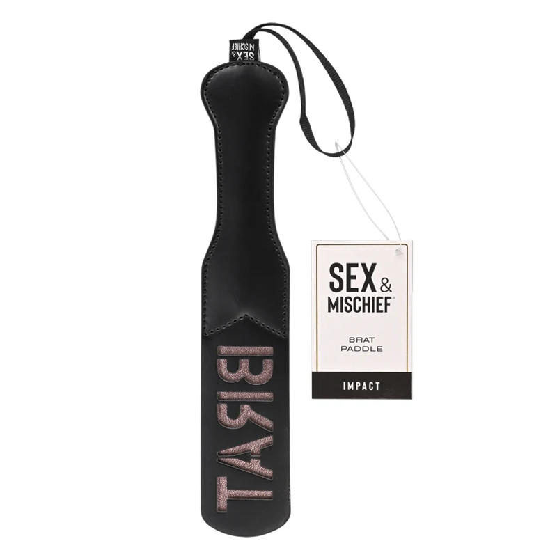 A black faux leather spanking paddle with rose gold lettering and a branded tag.