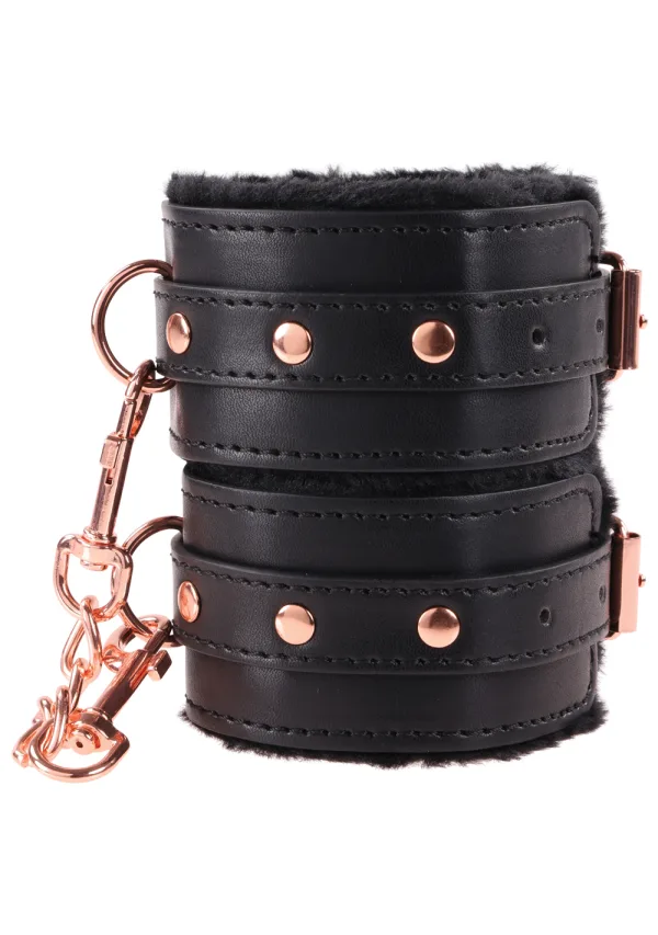 Black faux leather wrist restraints with rose gold hardware and black fur lining.