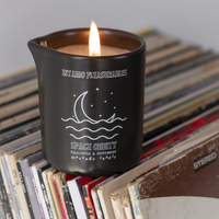 Black ceramic massage candle with a moon and stars design.