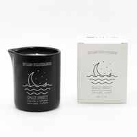 Black ceramic massage candle with "Space Oddity" design and eucalyptus peppermint scent.