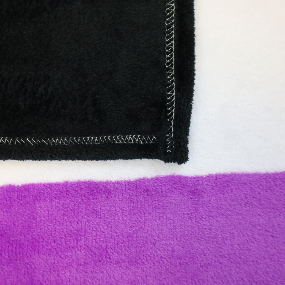 A black, white, and purple plush fleece blanket with visible stitching.