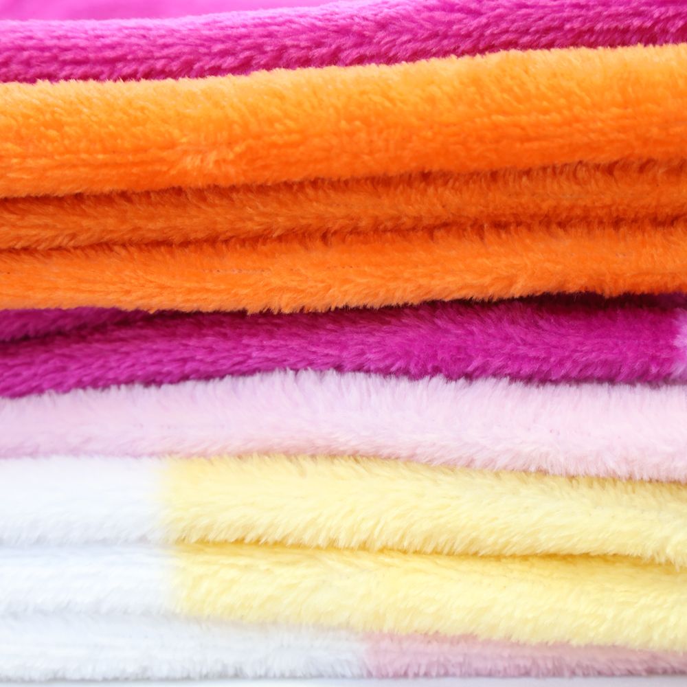 A stack of plush fleece blankets in sunset pride colors.