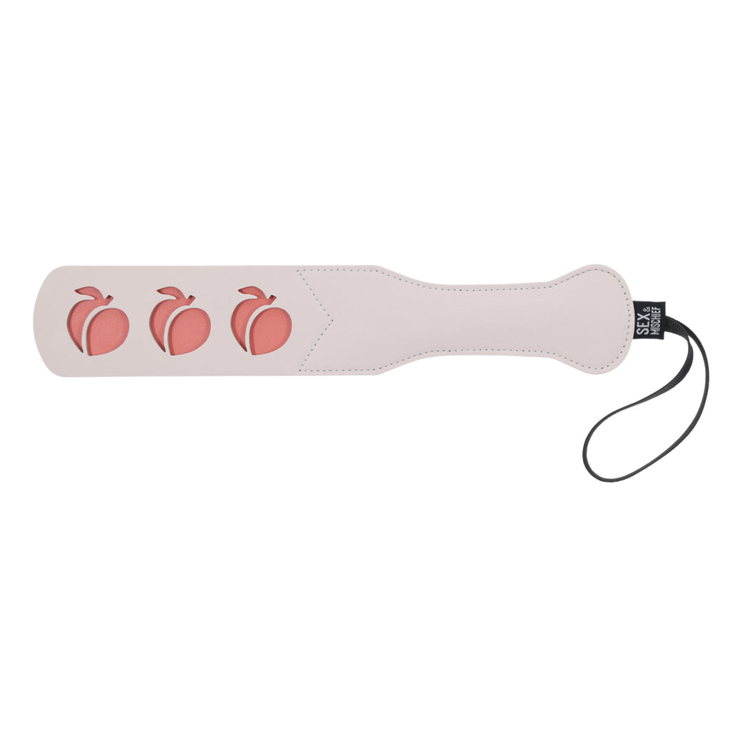 Faux leather paddle with three peach cutouts and a wrist strap.