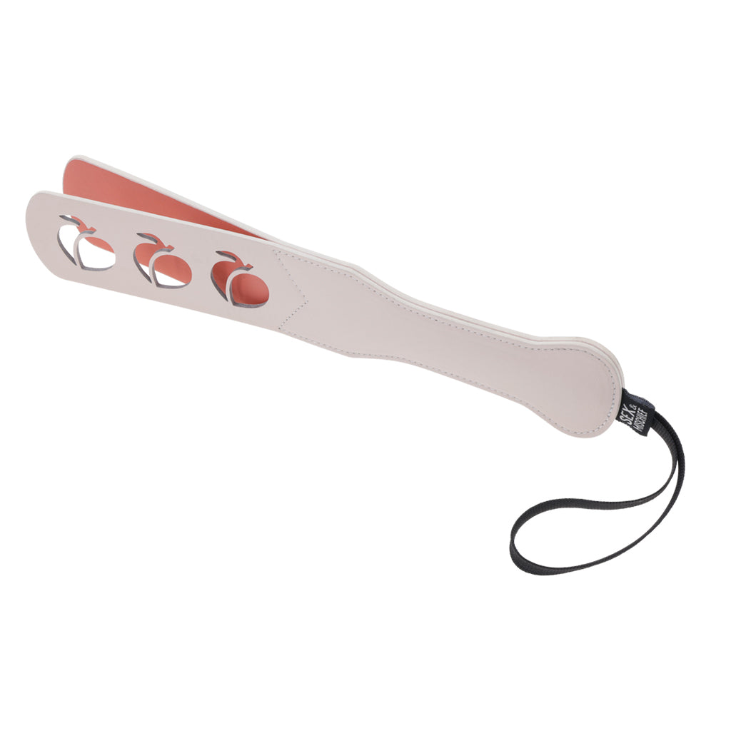 Faux leather paddle with peach cutouts and a wrist strap.