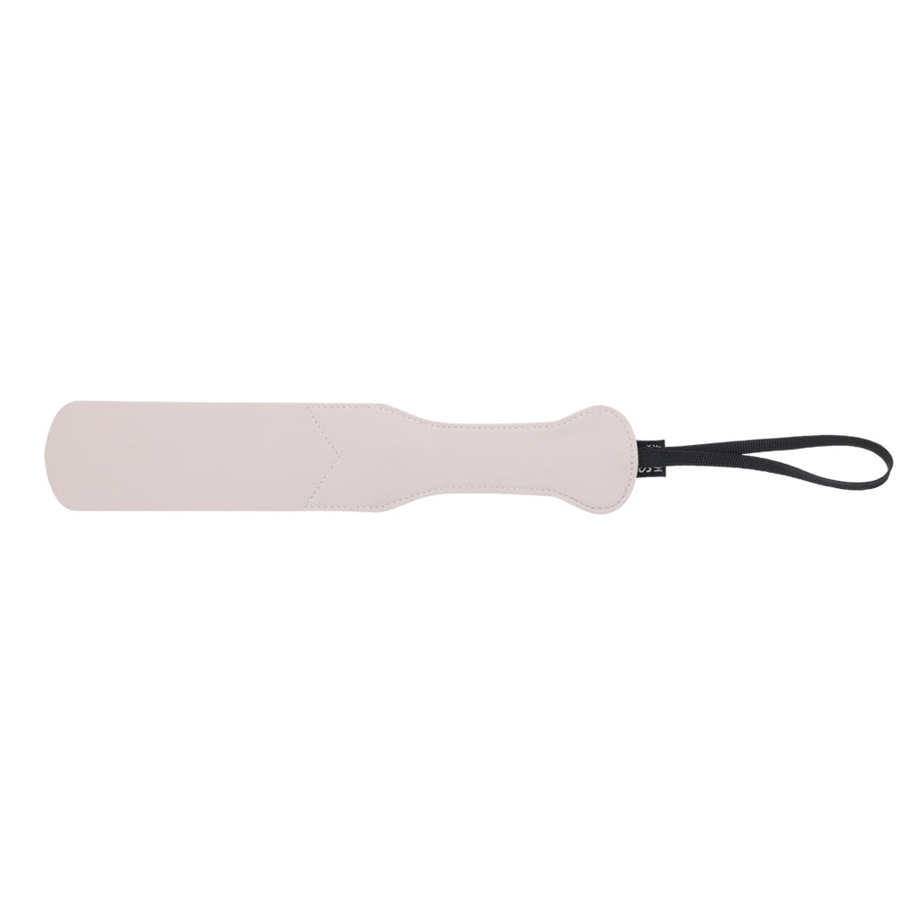 Faux leather peach impression paddle with a black wrist strap.