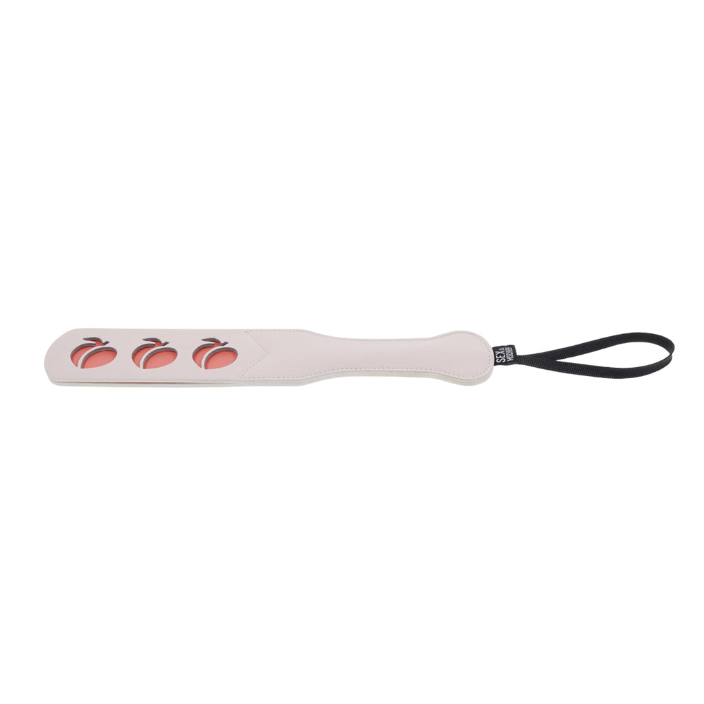 Faux leather paddle with peach cutouts and a wrist strap.