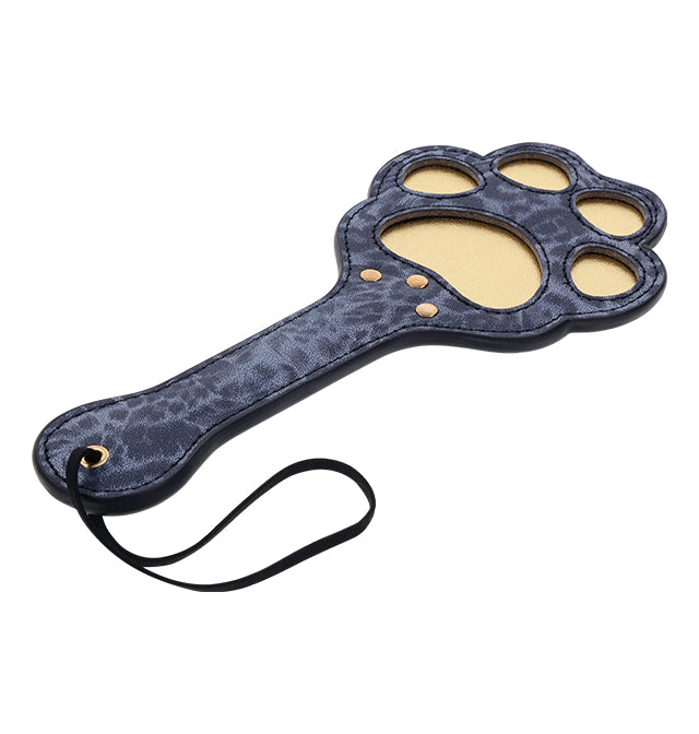 A blue leopard print faux leather paddle shaped like a cougar paw with cutouts and a wrist loop.