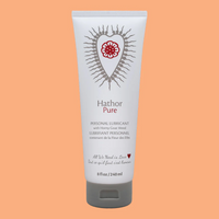 Hathor Pure personal lubricant in a white tube with a red floral heart design.