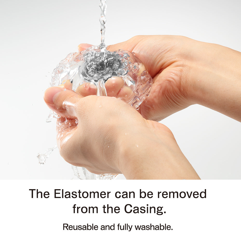 Hands washing a clear, textured masturbator under running water.