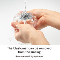Hands washing a clear, textured masturbator under running water.