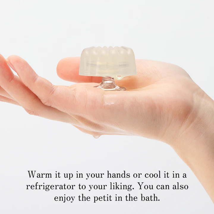 A clear, textured pleasure item rests on a hand, with text below.