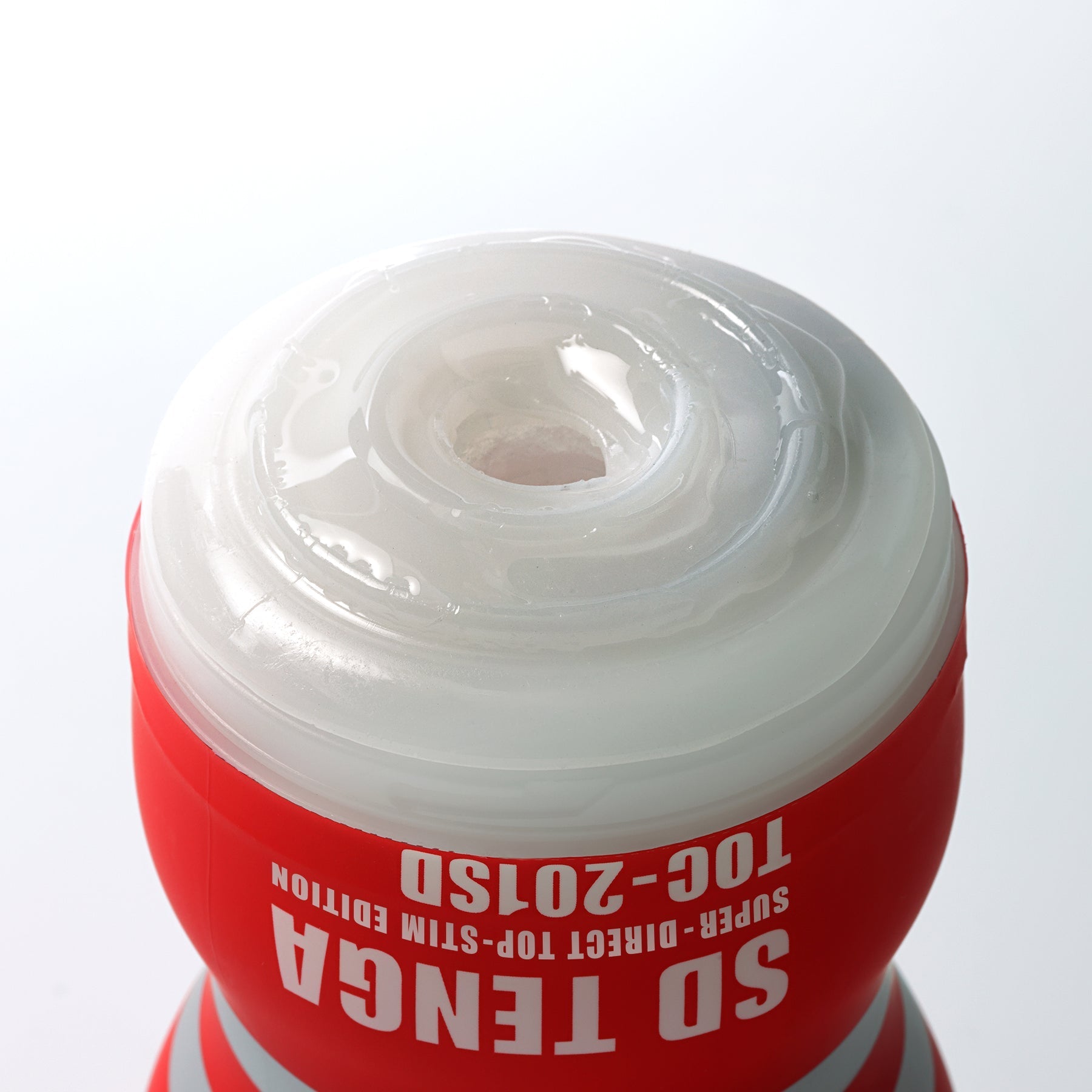 Original Tenga vacuum cup male masturbator with red casing and white textured opening.