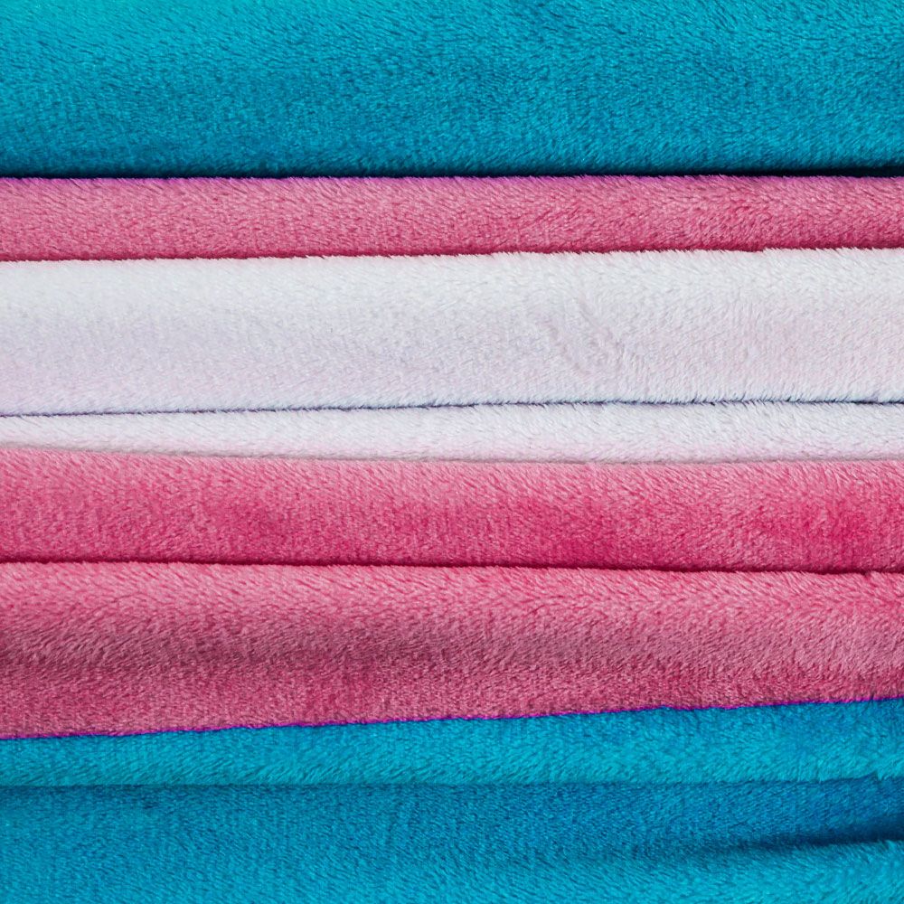 A stack of plush fleece blankets in transgender pride colors.