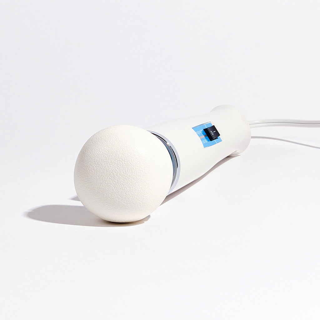 White cordless massager with a large round head and a power switch.