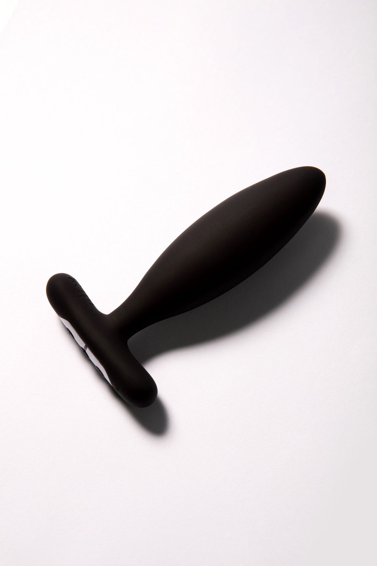 Black silicone vibrating butt plug with a T-shaped base and remote control.